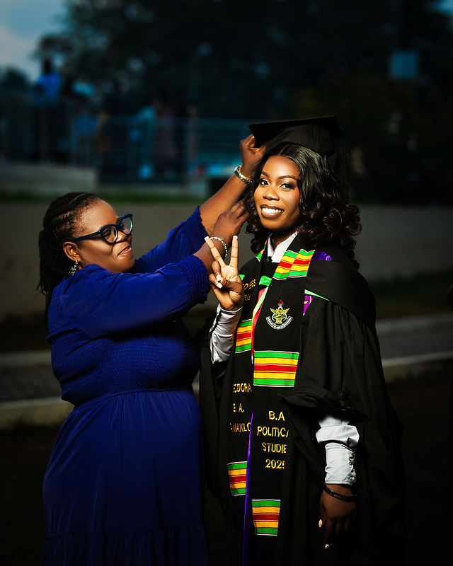 Mother adjusting her daughter's graduation cap while the graduate smiles and throws a peace sign